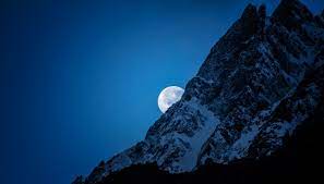 The moon creeping over a mountain